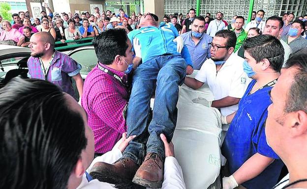 Personal médico asiste a los heridos del accidente de avión a su llegada a un hospital de la ciudad mexicana de Durango.