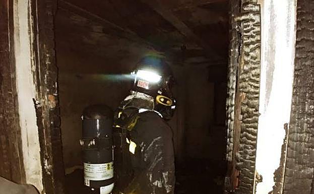 Bombero en la casa incendiada.