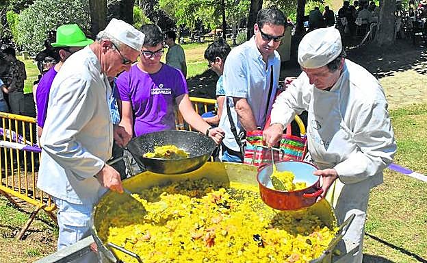 Los cocineros reparten la paella en Olleros de Pisuerga