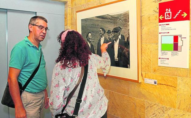 Dos visitantes observan las imágenes de la exposición. 