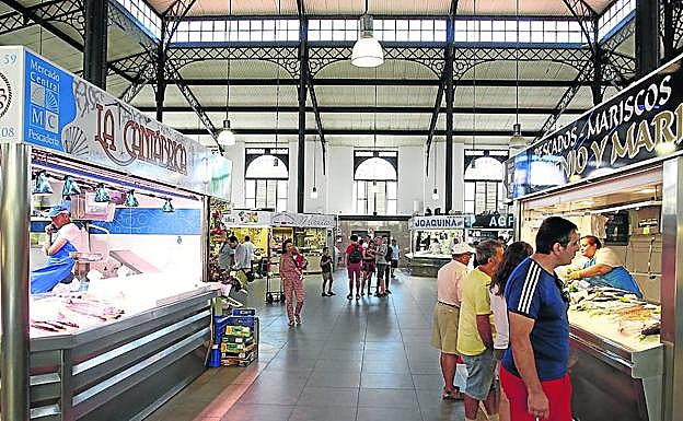 Los consumidores observan los productos que se venden en los puestos de alimentación. 