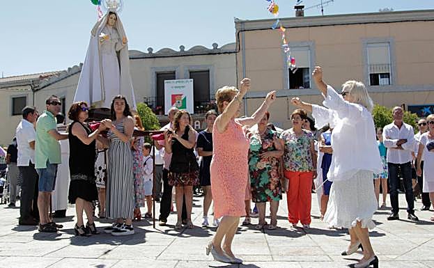 Dos mujeres bailan una jota delante del paso de la Virgen de la Asunción, en la plaza del pueblo. 