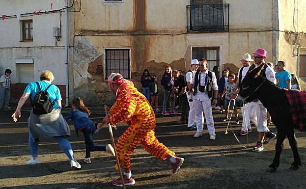 El chiborra corre tras los vecinos junto a su burro por las calles de Cisneros.