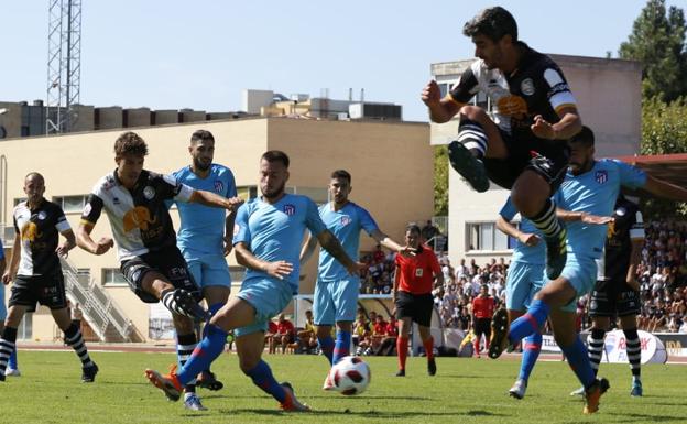 Ribelles lanza a portería en el gol de Unionistas mientras Cendrós salta para evitar ser golpeado. 