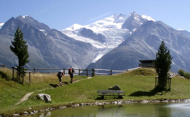 Unos montañeros caminan en 2007 a los pies de Ried Glacier y el Dom (montaña más alta de Suiza). 