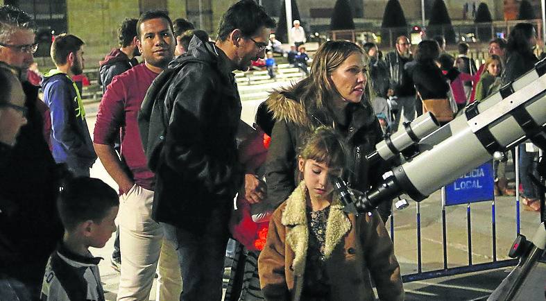 Un grupo de personas observa el cielo.