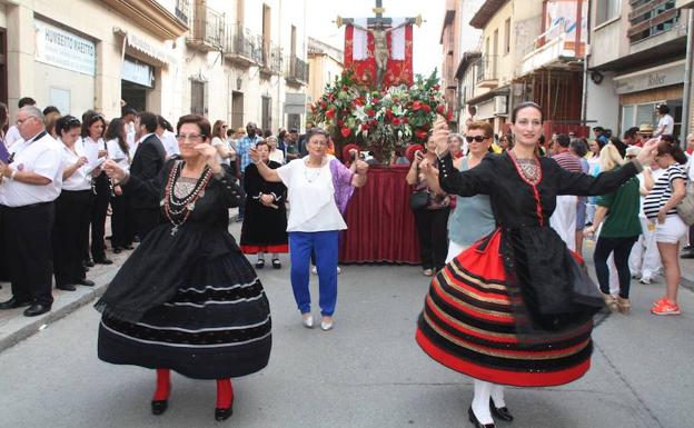 Vecinos de Nava bailan delante del Cristo durante la procesión.