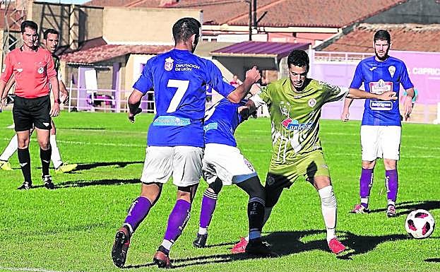 Adri se escapa por la banda para tratar de centrar ante la defensa de dos jugadores de La Bañeza. 