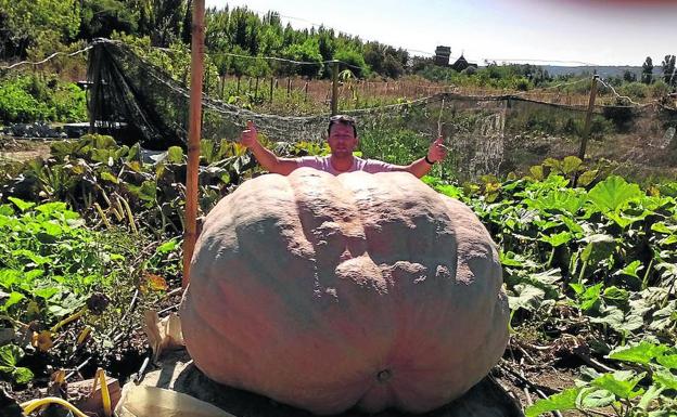 El escultor Sergio García posa con su calabaza.