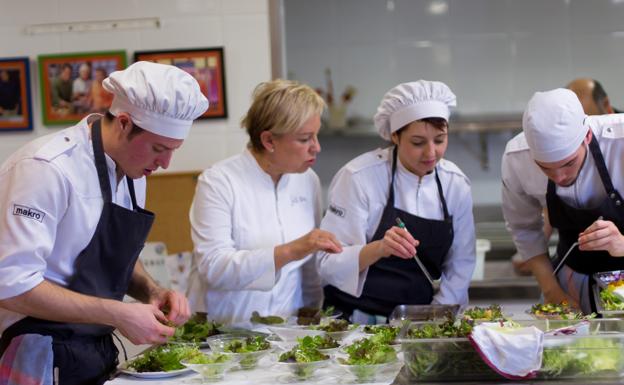 Susi Díaz, rodeada de varios jóvenes en sus cocinas del restaurante La Finca, en Elche.