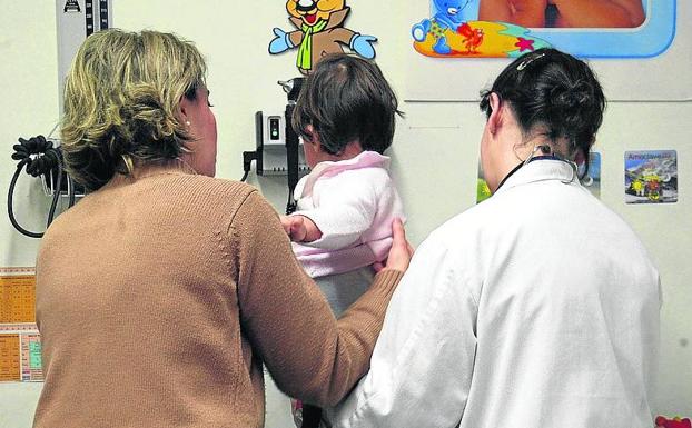Una niña es atendida por una pediatra en un centro de salud. 
