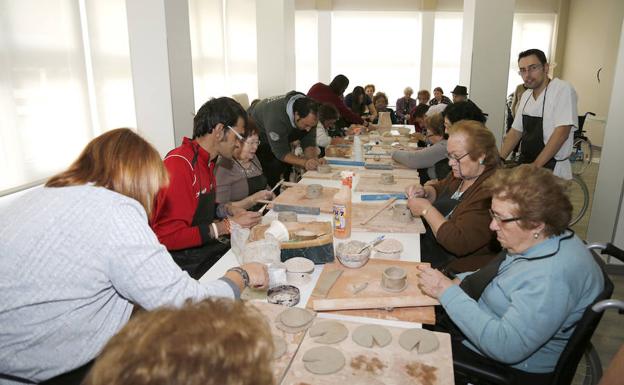 Miembros de la Fundación San Cebrián y personas mayores de la residencia Reina Isabel, durante el taller de cerámica. 