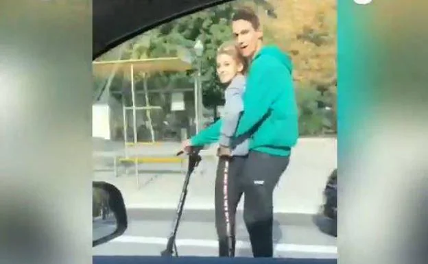 Los dos jóvenes en el patinete eléctrico.