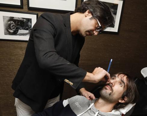 El propietario de la barbería Très Salon, Mariano Gómez, empieza a perfilar el bigote a Jordi Grimau.