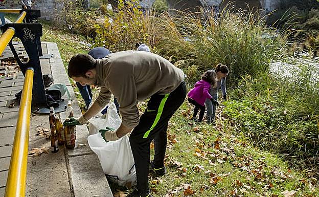 Pablo recoge varias botellas de cristal recogidas de las riberas de la Esgueva. 