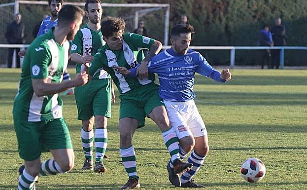 El centrocampista Guty trata de evitar la entrada de un jugador de la Cebrereña.