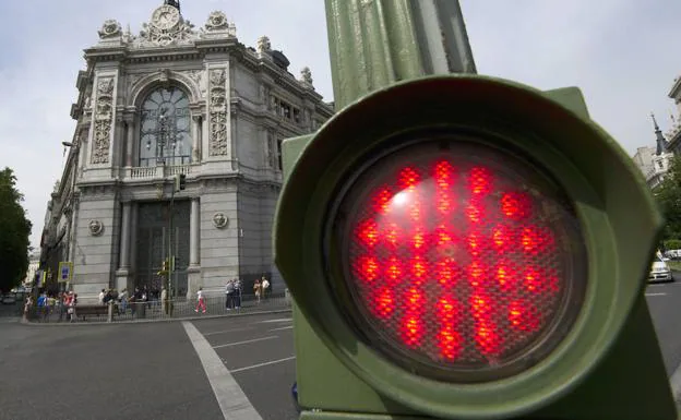 Semáforo en rojo al otro lado de la acera donde está ubicada la sede del Banco de España en Madrid. 
