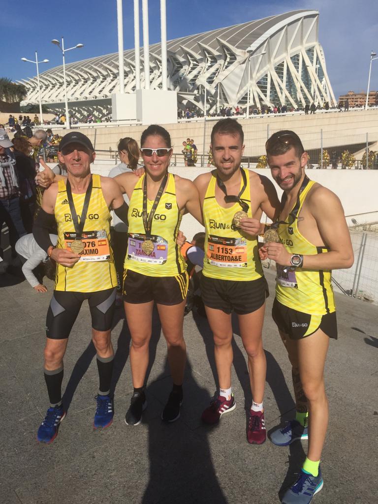 Cuatro corredores del Team Run&Go en la Maratón con sus medallas tras completar la prueba'. 