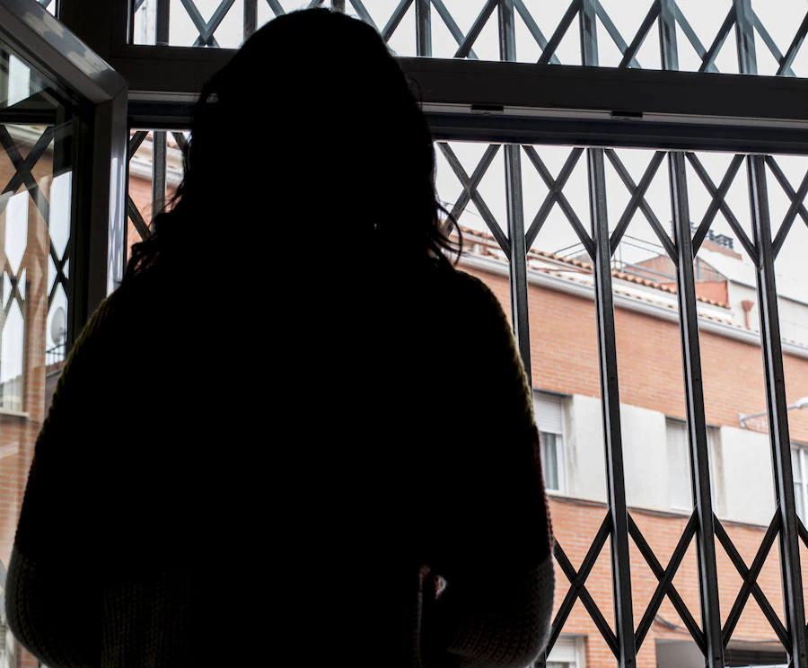 Una mujer observa la calle desde una venta de la sede de Aclad, en Valladolid. 