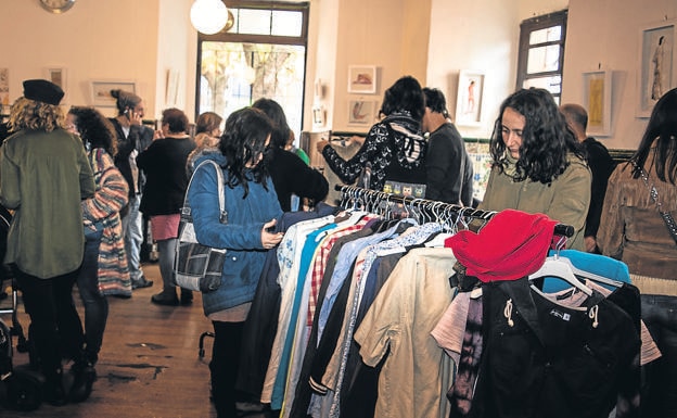 Varias personas revisan la ropa reunida para su trueque en El Penicilino 