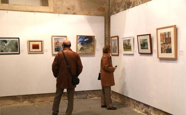 Dos visitantes en la exposición 'Artistas por el Sáhara' en la Casa de los Picos de Segovia. 