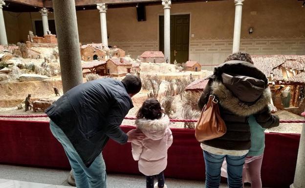 Una familia contempla las figuras y escenas del belén instalado en el Palacio Provincial.