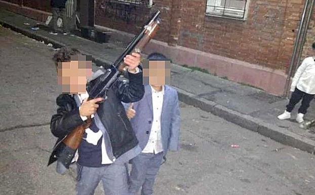 Dos menores posan con la escopeta. 