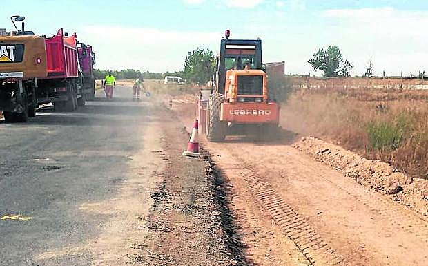 Máquinas y cuadrillas de operarios trabajan en el arreglo de una carretera provincial. 