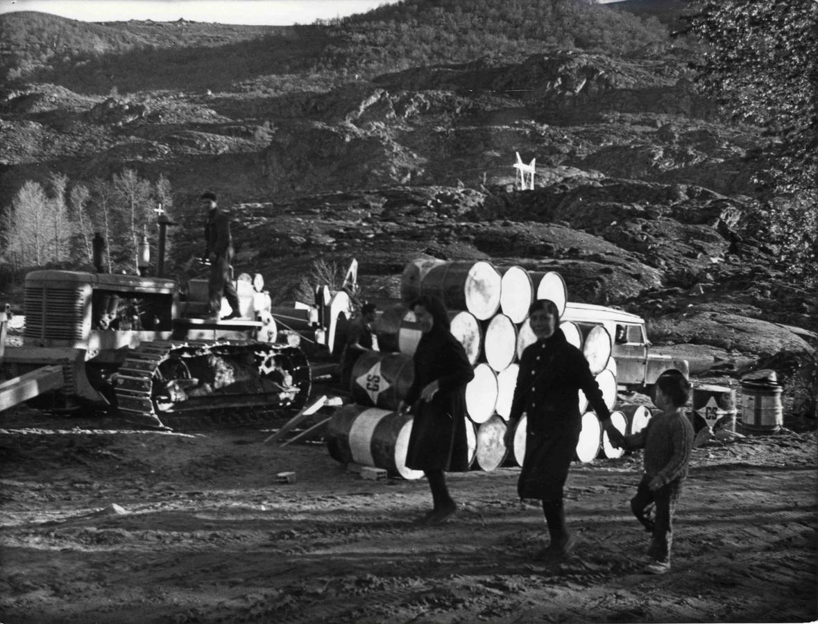 Una familia deambula entre las máquinas que trabajan enlo que quedó del pueblo.