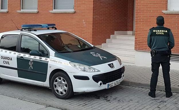 Una agente de la guardia civil vigila una vivienda.