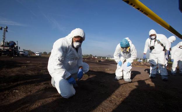 Los forenses mexicanos toman muestras en el lugar del siniestro, en Tlahuelilpan.