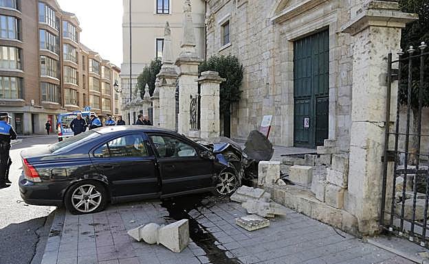 El choche siniestrado ha derribado parte del muro de la iglesia. 