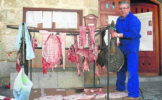 San Esteban de la Sierra. Colocando todas las piezas del cerdo en unos varales.