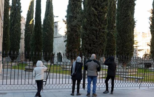 Un grupo de personas pasea junto al Patio de los Cipreses de la Catedral de Valladolid. 