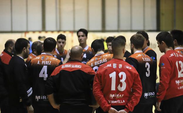 Los jugadores del BM Salamanca escuchan a su entrenador en un partido. 