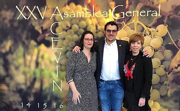 Judith Fernández y Beatriz Fernández Pujo, gerente y presidenta de la Asociación de la Ruta del Vino de Toro, flanquean al alcalde de Toro, Tomás del Bien, en la asamblea de Acevin en Huelva. 