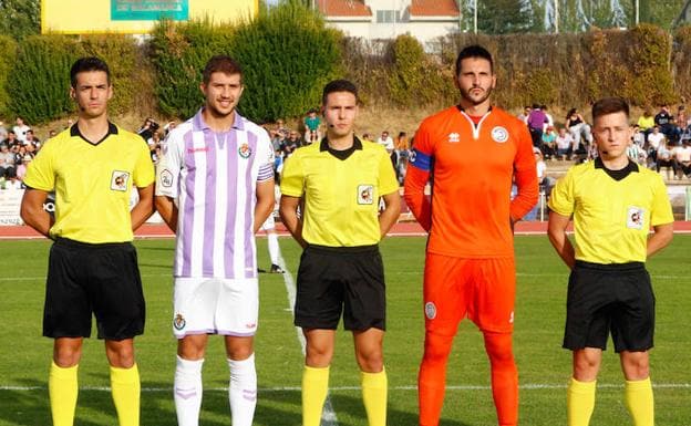 Los capitanes de Unionistas y Valladolid B posan con el trío arbitral en la primera vuelta. 