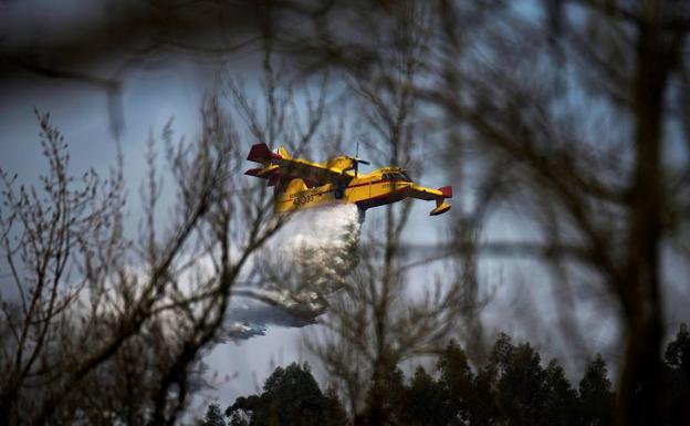 Un hidroavión descarga el agua sobre el incendio que afectó al municipio de Ramales de la Victoria (Cantabria).