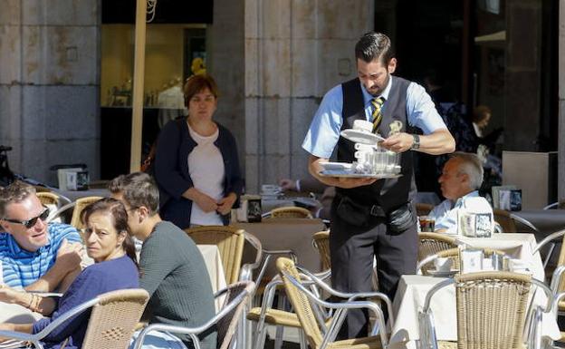 Un camarero sirve una consumición en la plaza Mayor de Salamanca. 