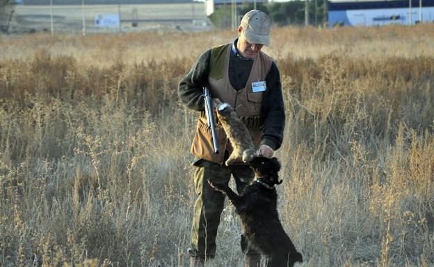 Un cazador, con su perro y una presa.