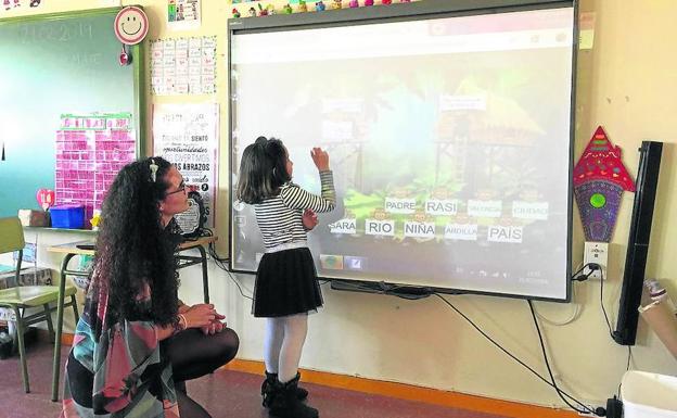 Una alumna del centro utiliza una pizarra digital.