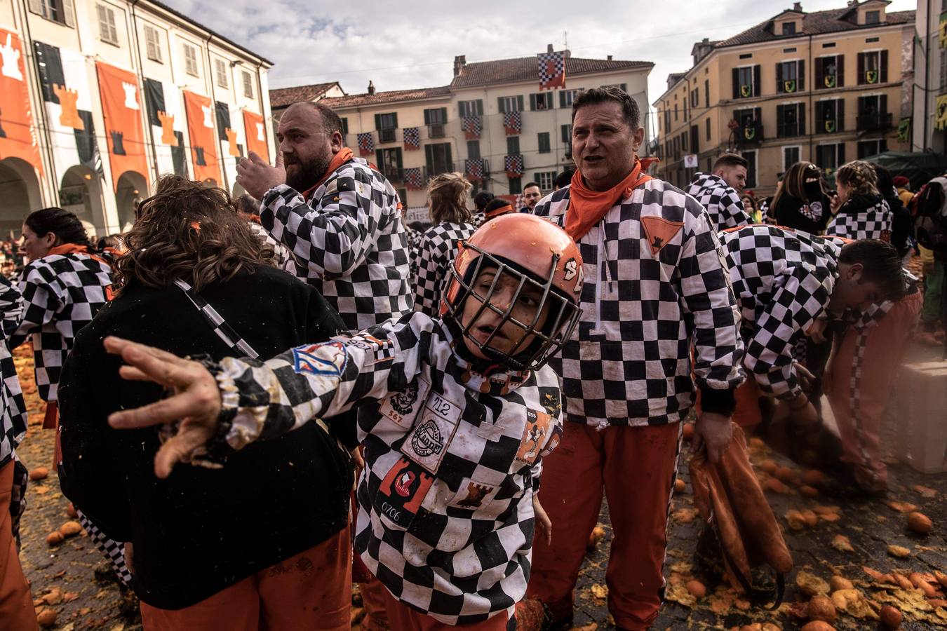 El histórico Carnaval de Ivrea, localidad de Piamonte en la provincia de Turín, representa la guerra civil entre el pueblo y las tropas reales napoleónicas, el día después de la muerte del odiado tirano Raineri de Bramante a manos de la 'Mugnaia' | Los equipos de lanzadores de naranjas a pie (el pueblo) defienden sus plazas de los lanzadores de los carros (el Estado Mayor Napoleónico) a golpe de naranja