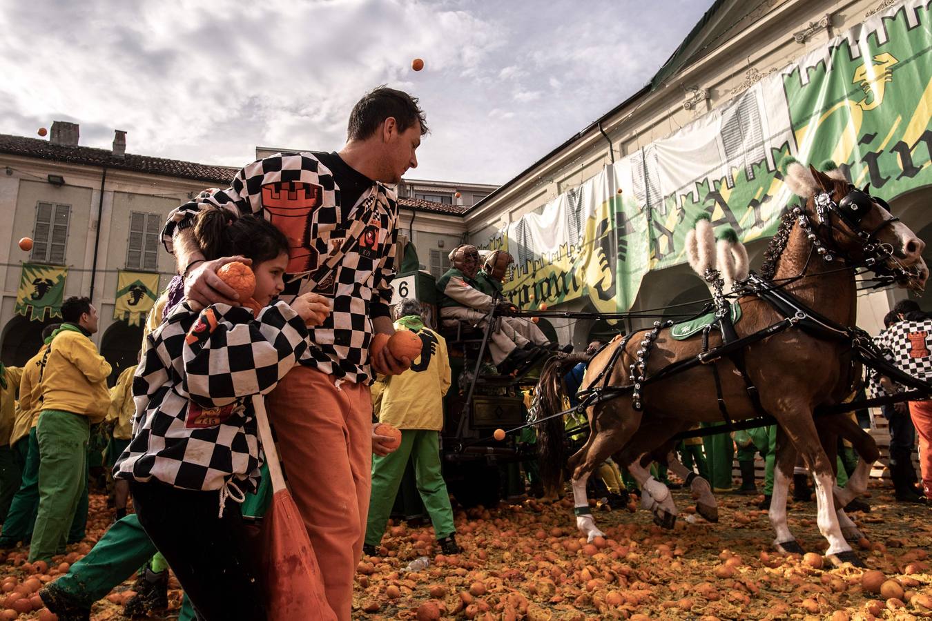 El histórico Carnaval de Ivrea, localidad de Piamonte en la provincia de Turín, representa la guerra civil entre el pueblo y las tropas reales napoleónicas, el día después de la muerte del odiado tirano Raineri de Bramante a manos de la 'Mugnaia' | Los equipos de lanzadores de naranjas a pie (el pueblo) defienden sus plazas de los lanzadores de los carros (el Estado Mayor Napoleónico) a golpe de naranja