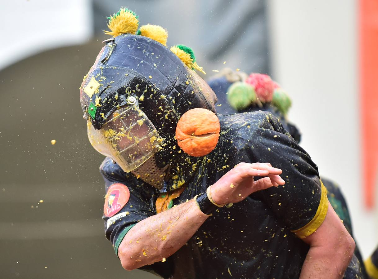 El histórico Carnaval de Ivrea, localidad de Piamonte en la provincia de Turín, representa la guerra civil entre el pueblo y las tropas reales napoleónicas, el día después de la muerte del odiado tirano Raineri de Bramante a manos de la 'Mugnaia' | Los equipos de lanzadores de naranjas a pie (el pueblo) defienden sus plazas de los lanzadores de los carros (el Estado Mayor Napoleónico) a golpe de naranja