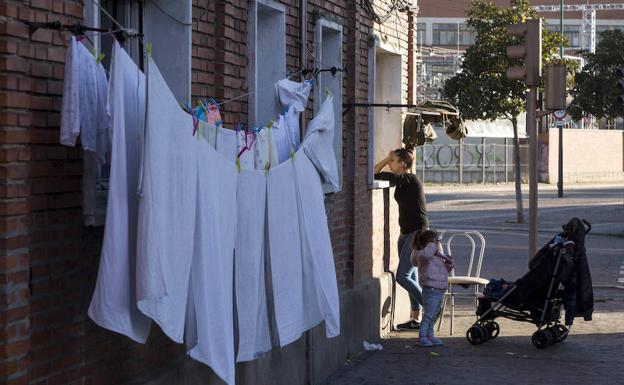 Imagen principal - Calle de La Viudas. Abajo, Cristian habla con una vecina y Óscar, en el baño de su vivienda. 