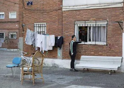 Imagen secundaria 1 - Calle de La Viudas. Abajo, Cristian habla con una vecina y Óscar, en el baño de su vivienda. 