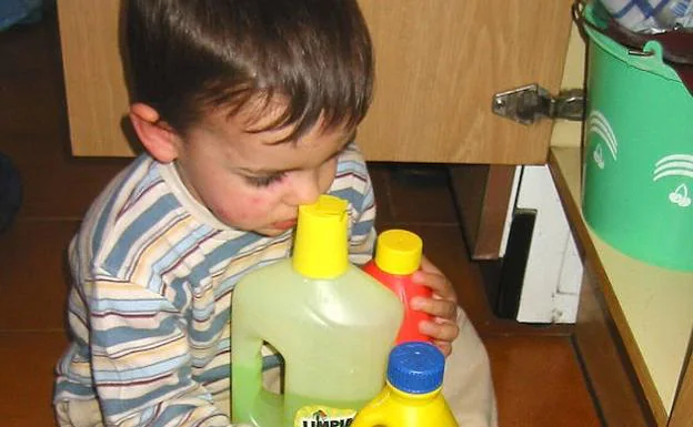 Un niño pequeño, con productos de limpieza. :: 