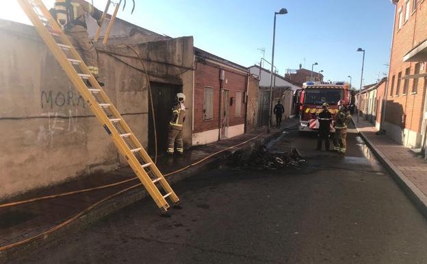 Bomberos trabjando en la calle afectada por las llamas.