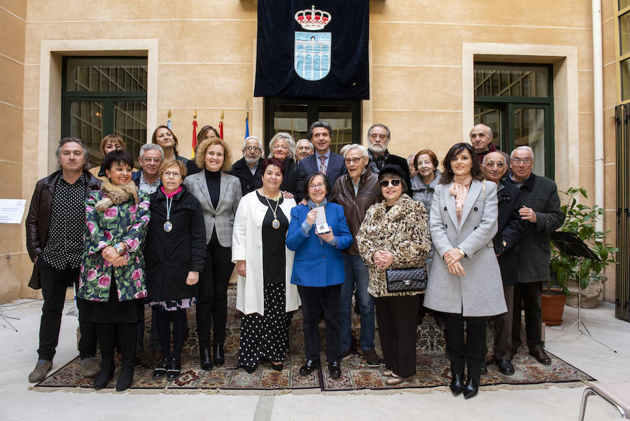 Miembros de la Soiecad Filarmónica posan con las autoridades tras la entrega de la medalla.