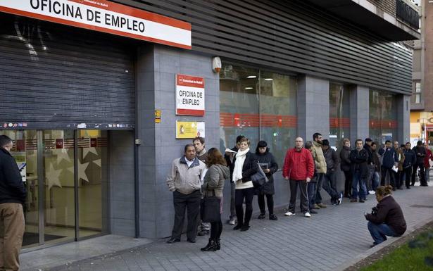 Parados haciendo cola a las puertas de una oficina de empleo.